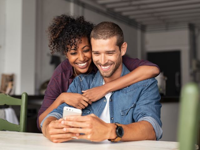 A young couple checking their FinalFYI messages on a mobile phone