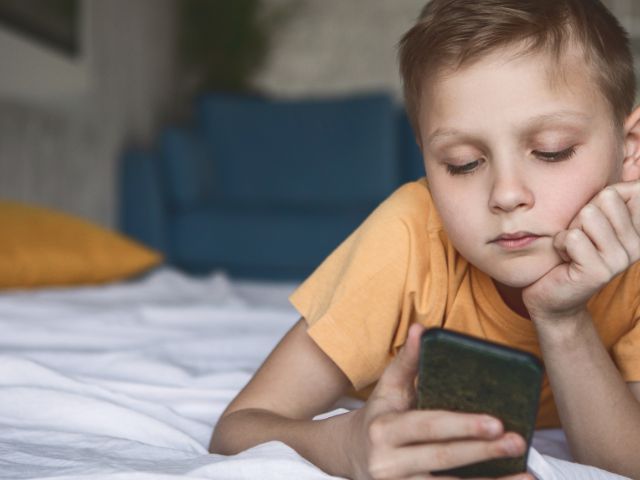 A kid checking his FinalFYI messages on his mobile phone