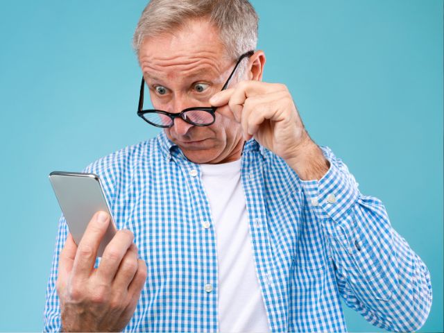 A man surprised by a FinalFYI message on his mobile phone