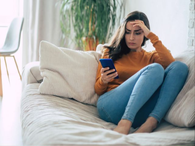 A young woman concerned when she receives a FinalFYI message on her mobile phone