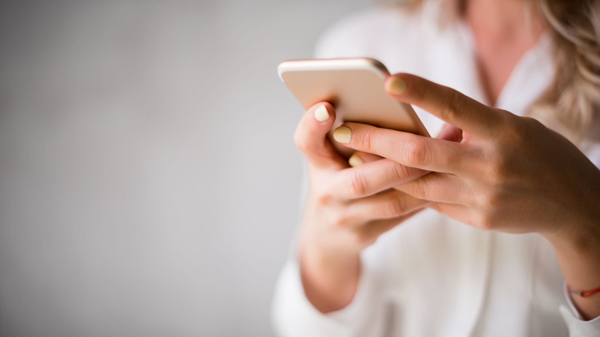 Woman types out her FinalFYI messages on a mobile phone